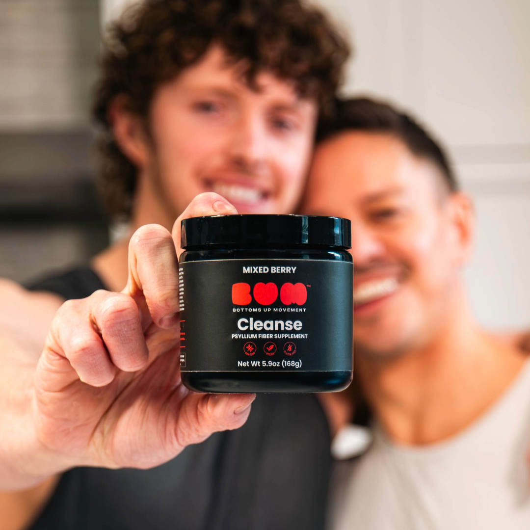 handsome man holding a supplement jar labeled 'Cleanse' with two other people in the background.